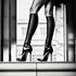 Élégantes jambes chaussées de hauts talons, capturées en noir et blanc dans une photo glamour