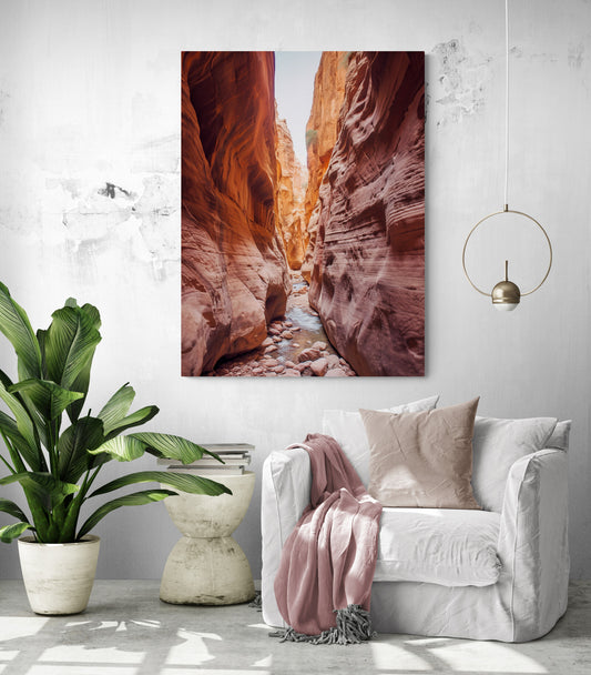 le tableau du canyon est suspendu dans un salon spacieux et lumineux. En dessous, il y a un canapé blanc confortable drapé d'une couverture rose pâle. À côté du canapé, une plante verte luxuriante ajoute une touche de nature à la pièce. Un luminaire suspendu au design minimaliste complète l'ambiance du salon