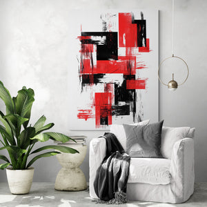Tableau rouge et noir aux touches graphiques accrochée sur un mur clair. Fauteuil blanc avec coussin et plaid gris. À gauche, grande plante tropicale dans un pot beige. Petite table en pierre avec des livres. Suspension dorée fine.