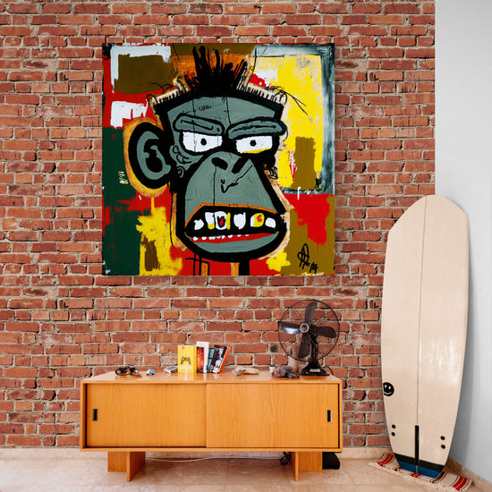 Affiche pop-art d’un singe stylisé aux couleurs vives, exposée sur un mur en briques dans un intérieur au style vintage. Un meuble bas en bois clair, une planche de surf, un ventilateur rétro et des objets décoratifs complètent l’atmosphère détendue et artistique
