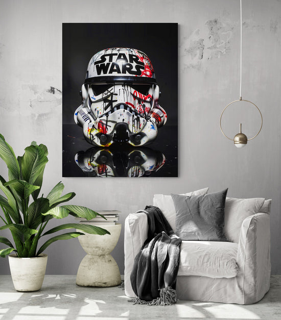 pièce de vie, fauteuil confortable, coussin et plaid noir, table d'appoint, grande plante verte, lumière en suspension, grand tableau noir star Wars