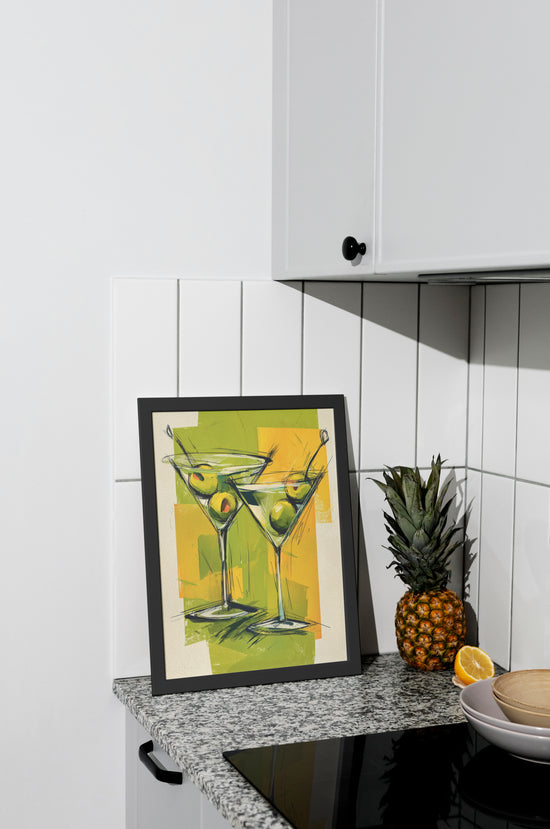 Affiche décorative de deux cocktails martini avec olives, posée sur un plan de travail de cuisine moderne.
