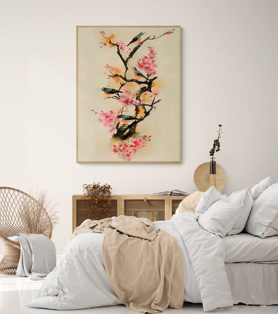 Tableau mural représentant des oiseaux bleus perchés sur des branches fleuries de cerisier sakura, dans une chambre au style bohème épuré avec lit cosy, mobilier en rotin et bois clair.