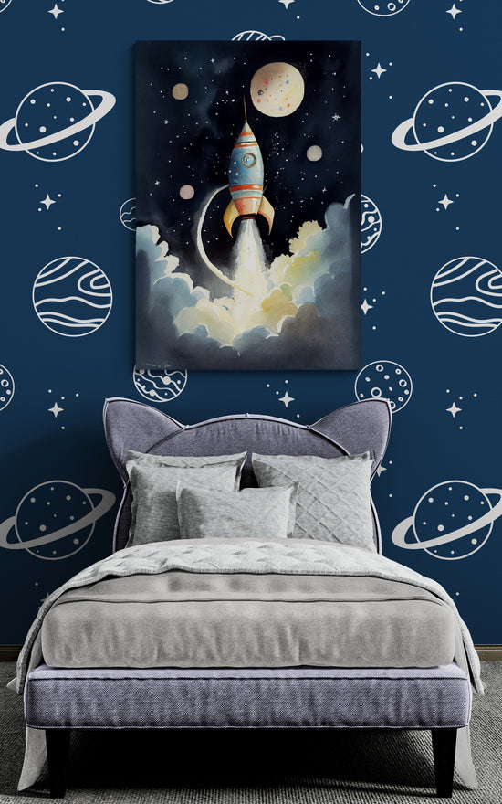 une chambre d'enfant décorée sur le thème de l'espace. Le mur est tapissé de motifs de planètes et d'étoiles blanches sur fond bleu nuit. Un grand lit avec une tête de lit en forme de chat est habillé de linge gris texturé. Un tableau représentant une fusée qui décolle à travers les nuages est accroché au mur.