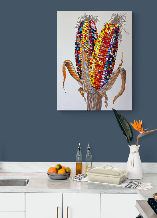 Tableau moderne de maïs multicolore sur mur bleu-gris dans une cuisine blanche.