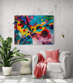 pièce de vie, tableau coloré, grande plante verte, fauteuil confortable, coussin et plaid rouge, table d'appoint.