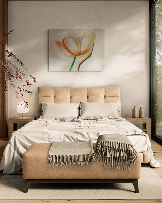 Une chambre moderne et épurée avec un tableau représentant une fleur tenue par une main au-dessus du lit. La pièce est décorée dans des tons neutres avec des touches de bois naturel, apportant une sensation de calme et de confort.