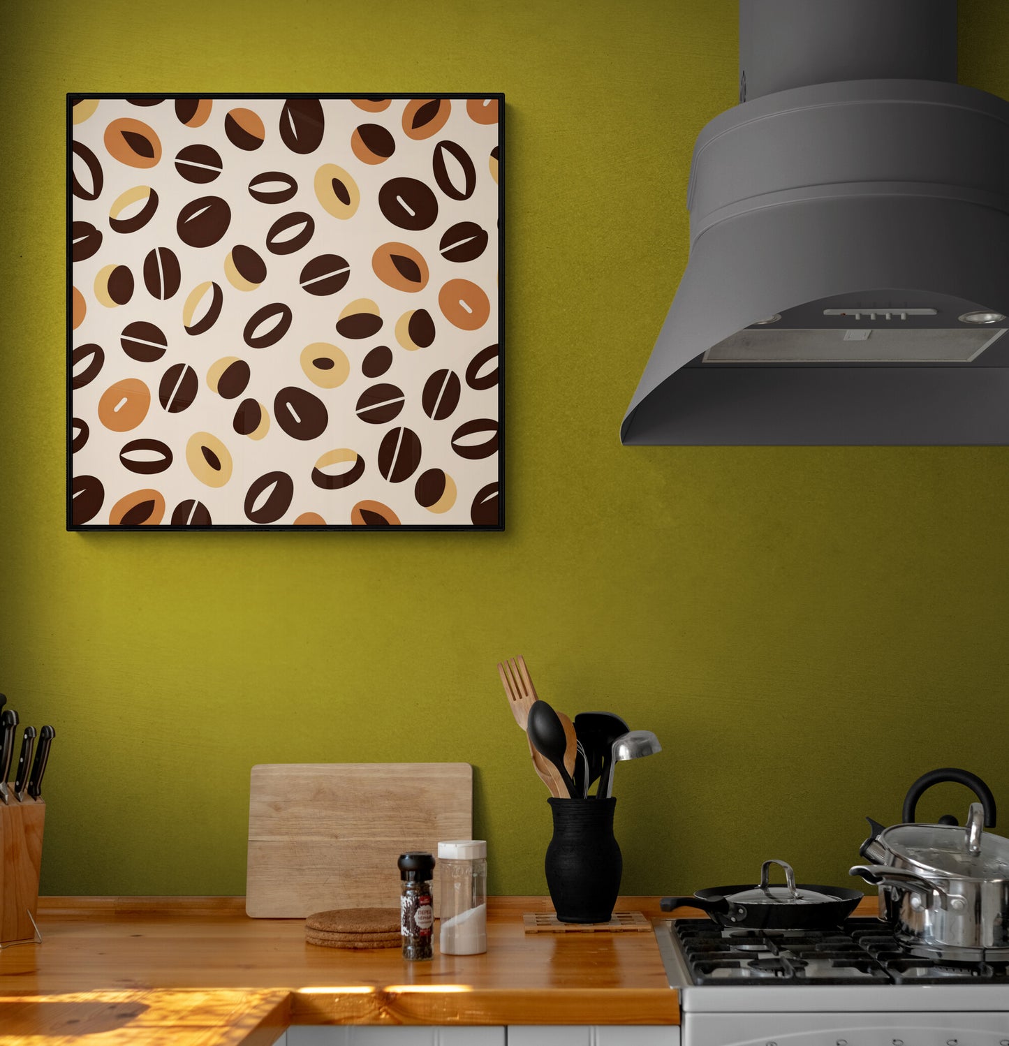 Tableau avec motifs de grains de café sur un mur vert olive, près d'ustensiles de cuisine noirs et d'un plan de travail en bois.