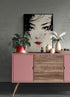 Commode rose avec dessus en bois affichant un tableau de geisha, entouré de plantes décoratives.