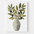 Affiche d’un vase rayé garni de branches d’olivier, mise en valeur dans une cuisine décorée avec des éléments modernes et naturels (plantes, carafe métallique, fruits). L’ensemble évoque fraîcheur et authenticité.