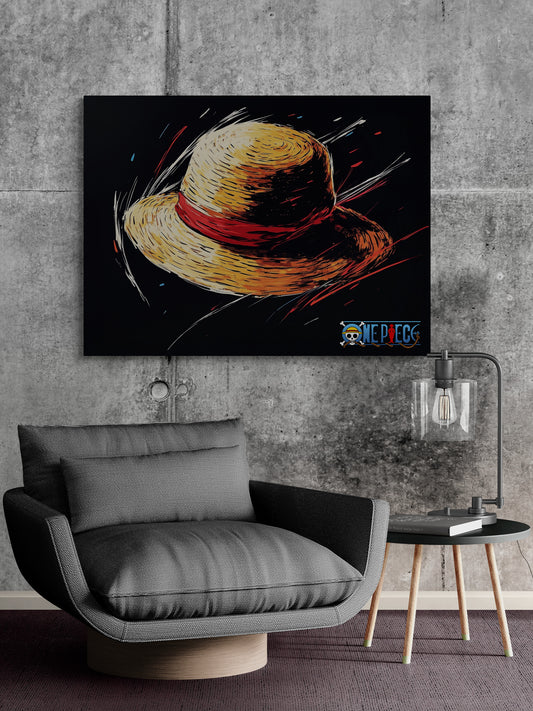 Un tableau décoratif affichant un chapeau de paille sur fond noir, fixé sur un mur en béton brut. En dessous, un fauteuil bas et confortable gris est accompagné d’une petite table avec une lampe au design moderne.