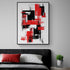 Tableau abstrait aux formes rectangulaires rouges et noires, avec des traits brossés sur fond blanc. Accroché au mur gris au-dessus d’un lit moderne. Tête de lit noire, oreiller blanc, coussin rouge. Petite table d’appoint avec une plante verte en pot.