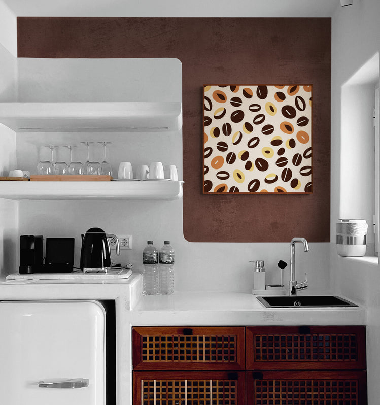 Tableau de grains de café sur fond crème, accroché sur un mur marron dans une cuisine moderne blanche avec des étagères flottantes.