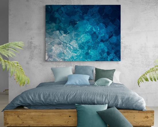 Tableau bleu d'eau au-dessus d'un lit en bois dans une chambre