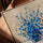 Tableau fleurs bleues dans vase beige, toile texturée cadre chêne doré salon moderne