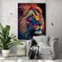 ableau pop art d'un lion aux couleurs vibrantes (bleu, rouge, orange, jaune), accroché dans un salon contemporain au design épuré. L'arrière-plan est composé d'un mur blanc texturé, une chaise grise avec une couverture, une lampe suspendue dorée et une plante verte pour une touche naturelle