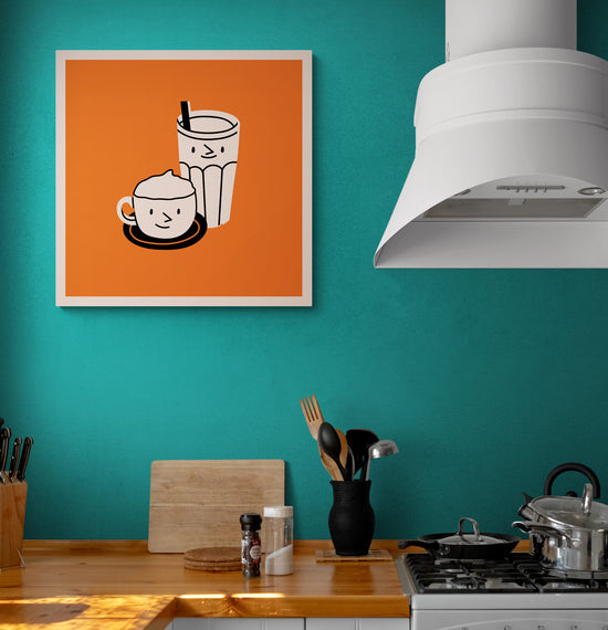 Tableau de boissons cartoon sur fond orange accroché sur un mur bleue turquoise, à côté d'une cuisine moderne avec plan de travail en bois.