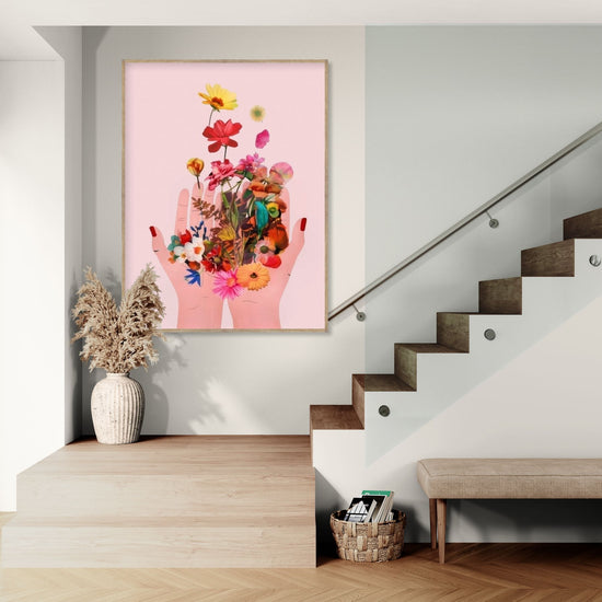 Tableau décoratif avec fleurs et mains sur fond rose dans une entrée moderne, ambiance florale et apaisante