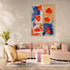 Tableau floral aux touches de rouge et bleu sur fond beige, style abstrait, dans un salon cosy et moderne