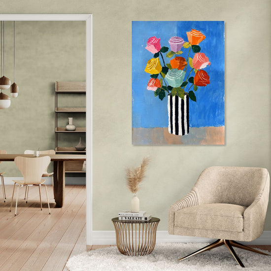 Tableau floral coloré sur fond bleu vif, vase à rayures noir et blanc, ambiance moderne et chic