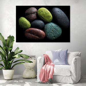 Tableau de galets colorés sur fond noir, ambiance moderne et naturelle avec fauteuil blanc et plante verte