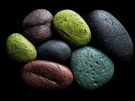 Tableau de galets colorés sur fond noir, style zen et naturel