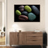 Tableau mural représentant des pierres colorées sur fond noir, style moderne et zen, dans un intérieur minimaliste