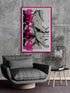 Un fauteuil gris moderne avec une table d'appoint, et un poster de Majin Buu en noir et blanc avec un cadre rose vif sur un mur en béton.