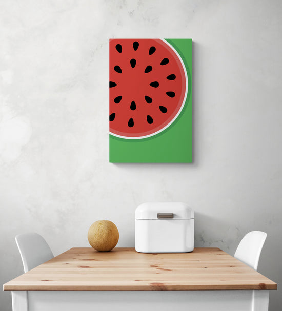 Le tableau pour cuisine est suspendu sur le mur blanc, avec des couleurs vives, du rouge et du vert. En dessous du tableau murale se trouve une table et deux chaises blanches, qui semblent être en contraste avec les couleurs vibrantes du tableau. Sur la table se trouve une corbeille à pain en métal blanc et un petit melon. Tous ces éléments créent un look frais et coloré dans la pièce.