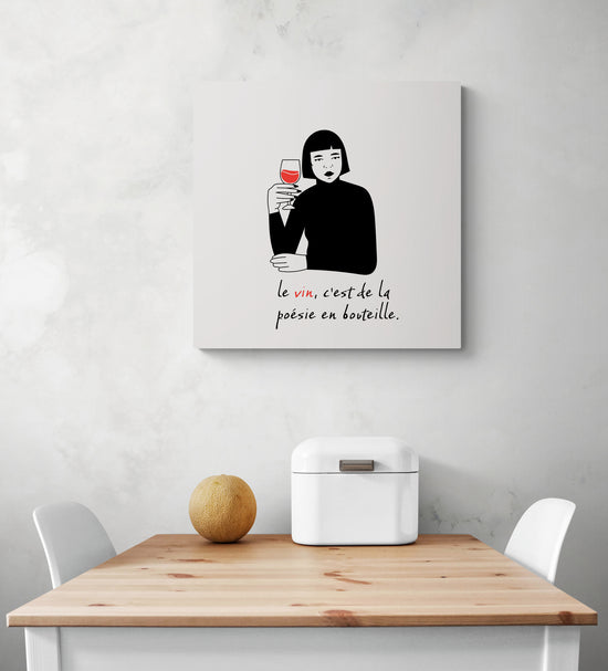 un cadre citation cuisine est accroché sur le mur d'une cuisine en dessous une table de repas.