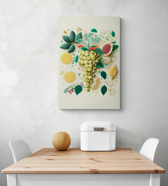 Un tableau cuisine déco est accroche au milieu d'un mur de blanc. Sur ce tableau une grappe de raisin vert entouré de feuille verte et de tranche de citron. Ce tableau apporte de la fraîcheur et la palette de couleur et douce. Au dessous une table de repas en pin et deux chaises blanches face à face