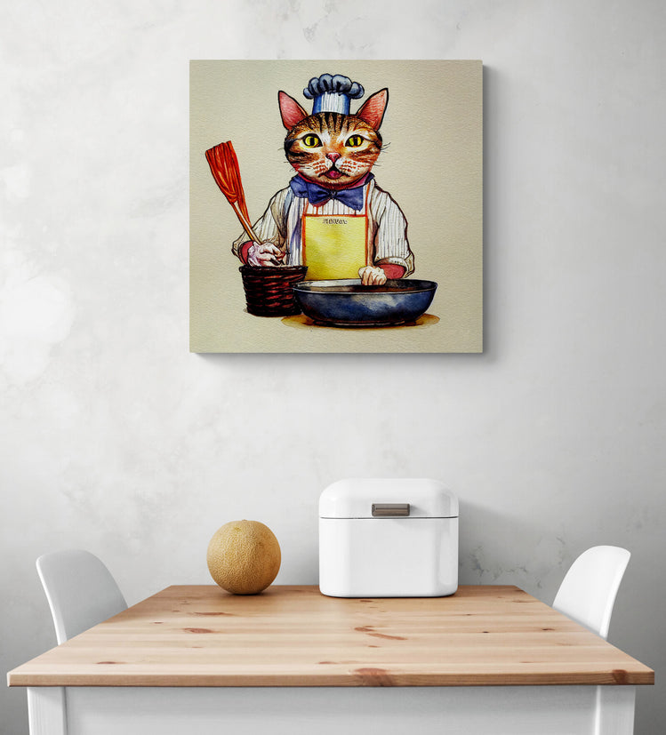Pour décorer une cuisine, accrochée sur le mur, il y a un tableau de chat qui se tient de face et prêt à cuisiner. Ces une impression sur toile qui reprend les codes du dessin à la main. Dans la pièce il y a une table en bois et deux chaises blanches. Une corbeille à pain en métal blanc et un melon sont sur le dessus de la table.